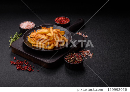 Fried crispy French fries with salt, spices, food for lunch 129992056