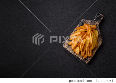 Fried crispy French fries with salt, spices, food for lunch 129992061
