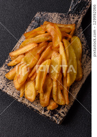 Fried crispy French fries with salt, spices, food for lunch 129992066