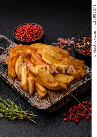 Fried crispy French fries with salt, spices, food for lunch Fried crispy French fries with salt, spices, food for lunch 129992071