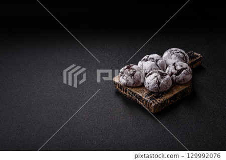 Chocolate crinkle cookies sprinkled with powdered sugar, homemade baking Chocolate crinkle cookies sprinkled with powdered sugar, homemade baking 129992076