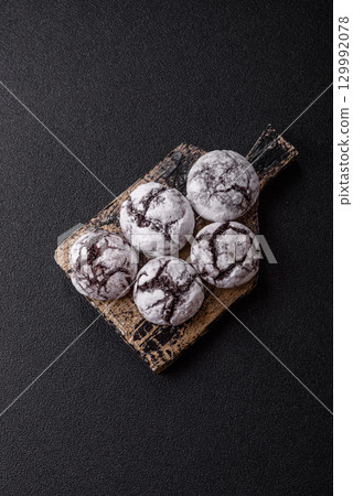 Chocolate crinkle cookies sprinkled with powdered sugar, homemade baking Chocolate crinkle cookies sprinkled with powdered sugar, homemade baking 129992078