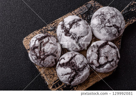 Chocolate crinkle cookies sprinkled with powdered sugar, homemade baking Chocolate crinkle cookies sprinkled with powdered sugar, homemade baking 129992081