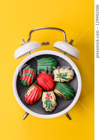 Christmas, gingerbread or madeleine on a plate on a vintage clock. Christmas conceptual background Christmas, gingerbread or madeleine on a plate on a vintage clock. Christmas conceptual background 129992086