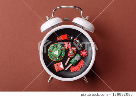 Christmas, eclair on a plate on a vintage clock. Christmas time conceptual background Christmas, eclair on a plate on a vintage clock. Christmas time conceptual background 129992093