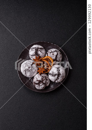 Chocolate crinkle cookies sprinkled with powdered sugar, homemade baking Chocolate crinkle cookies sprinkled with powdered sugar, homemade baking 129992130