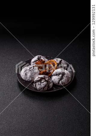 Chocolate crinkle cookies sprinkled with powdered sugar, homemade baking Chocolate crinkle cookies sprinkled with powdered sugar, homemade baking 129992131