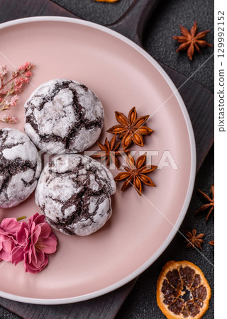 Chocolate crinkle cookies sprinkled with powdered sugar, homemade baking Chocolate crinkle cookies sprinkled with powdered sugar, homemade baking 129992152