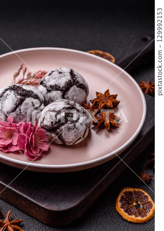 Chocolate crinkle cookies sprinkled with powdered sugar, homemade baking Chocolate crinkle cookies sprinkled with powdered sugar, homemade baking 129992153