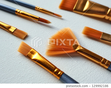 Close-Up of Art Brushes on Canvas in Various Shapes and Sizes 129992186