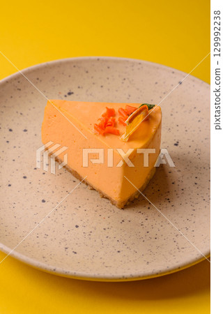 A slice of yellow cheesecake cake flavored with lemon and passion fruit 129992238