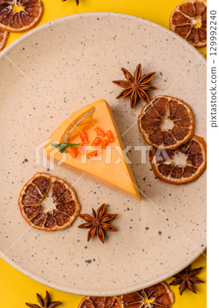 A slice of yellow cheesecake cake flavored with lemon and passion fruit 129992240
