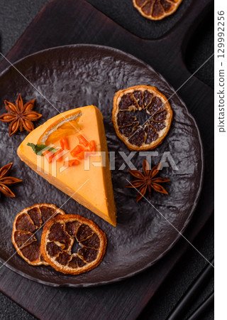 A slice of yellow cheesecake cake flavored with lemon and passion fruit 129992256