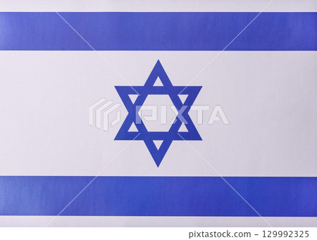 Israeli flag in white and blue colors as a symbol of independence. Flag of Israel Israeli flag in white and blue colors as a symbol of independence. Flag of Israel 129992325