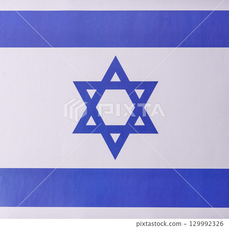 Israeli flag in white and blue colors as a symbol of independence. Flag of Israel Israeli flag in white and blue colors as a symbol of independence. Flag of Israel 129992326