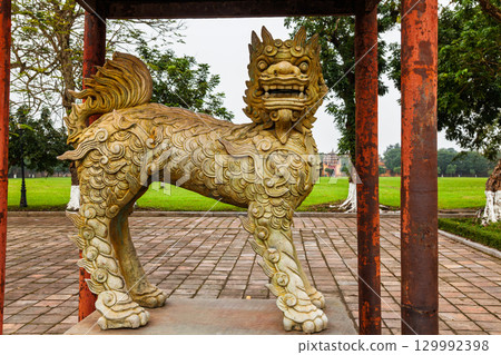 Ancient stone guardian lion statue with intricate details at the Imperial City of Hue Vietnam 129992398