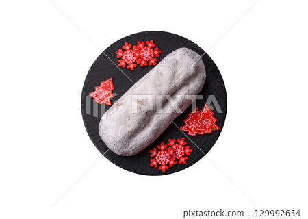 Christmas Stollen, a German sweet cake with marzipan and fruit. Winter Christmas Stollen Christmas Stollen, a German sweet cake with marzipan and fruit. Winter Christmas Stollen 129992654