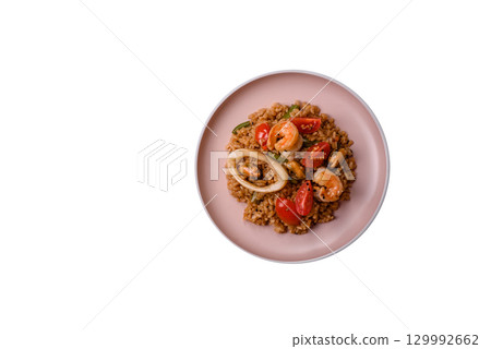 Rice and prawns or paella, a meal with seafood and vegetables. Cooked rice with shrimp 129992662
