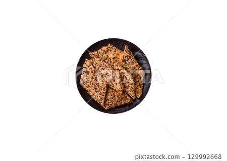 Crispbread, thin bread with seeds and grains, a baked cracker. Crispbread with sesame seeds Crispbread, thin bread with seeds and grains, a baked cracker. Crispbread with sesame seeds 129992668