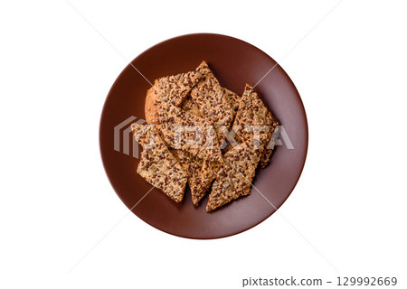Crispbread, thin bread with seeds and grains, a baked cracker. Crispbread with sesame seeds 129992669