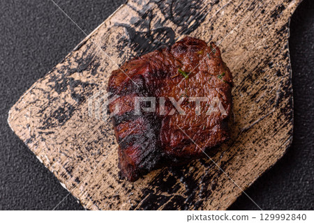 Grilled beef steak meat with salt and pepper. Beef steak grilled on a barbecue Grilled beef steak meat with salt and pepper. Beef steak grilled on a barbecue 129992840