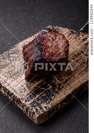 Grilled beef steak meat with salt and pepper. Beef steak grilled on a barbecue Grilled beef steak meat with salt and pepper. Beef steak grilled on a barbecue 129992844
