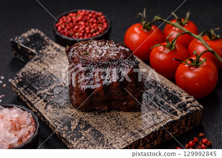 Grilled beef steak meat with salt and pepper. Beef steak grilled on a barbecue Grilled beef steak meat with salt and pepper. Beef steak grilled on a barbecue 129992845