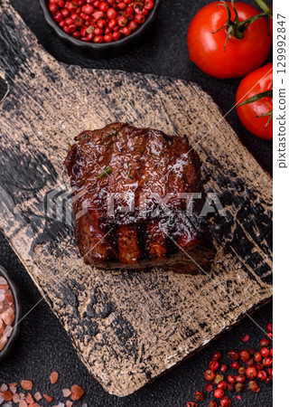 Grilled beef steak meat with salt and pepper. Beef steak grilled on a barbecue 129992847