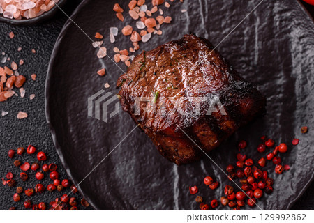Grilled beef steak meat with salt and pepper. Beef steak grilled on a barbecue 129992862