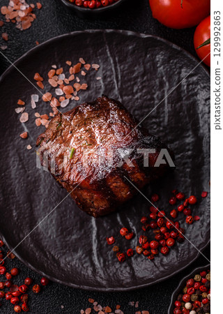 Grilled beef steak meat with salt and pepper. Beef steak grilled on a barbecue Grilled beef steak meat with salt and pepper. Beef steak grilled on a barbecue 129992863