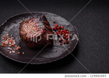 Grilled beef steak meat with salt and pepper. Beef steak grilled on a barbecue 129992865