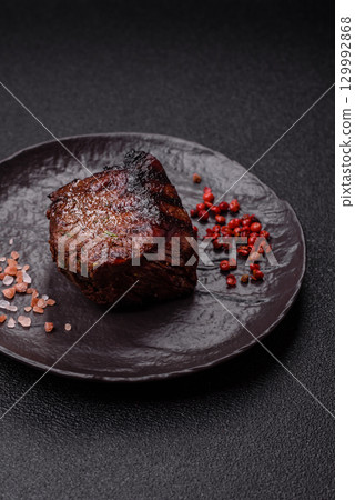 Grilled beef steak meat with salt and pepper. Beef steak grilled on a barbecue 129992868