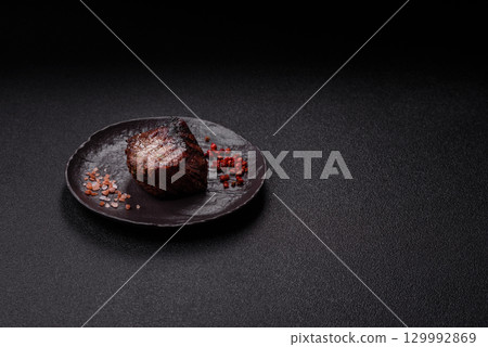 Grilled beef steak meat with salt and pepper. Beef steak grilled on a barbecue Grilled beef steak meat with salt and pepper. Beef steak grilled on a barbecue 129992869