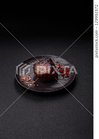 Grilled beef steak meat with salt and pepper. Beef steak grilled on a barbecue 129992872