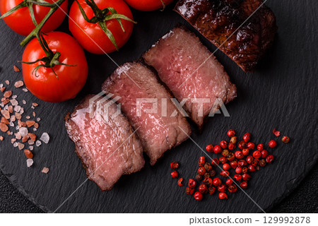 Grilled beef steak meat with salt and pepper. Beef steak grilled on a barbecue 129992878