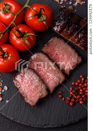 Grilled beef steak meat with salt and pepper. Beef steak grilled on a barbecue 129992879
