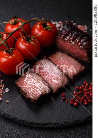 Grilled beef steak meat with salt and pepper. Beef steak grilled on a barbecue Grilled beef steak meat with salt and pepper. Beef steak grilled on a barbecue 129992880