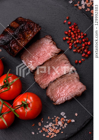 Grilled beef steak meat with salt and pepper. Beef steak grilled on a barbecue Grilled beef steak meat with salt and pepper. Beef steak grilled on a barbecue 129992883