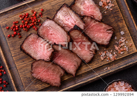 Grilled beef steak meat with salt and pepper. Beef steak grilled on a barbecue 129992894
