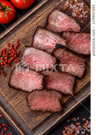 Grilled beef steak meat with salt and pepper. Beef steak grilled on a barbecue 129992895