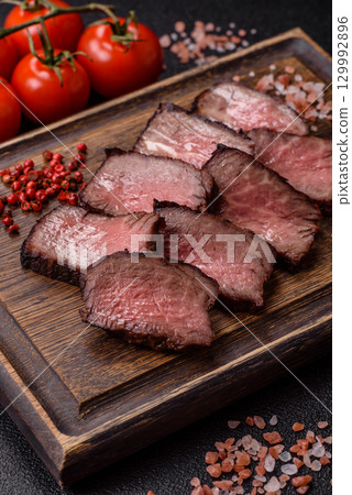 Grilled beef steak meat with salt and pepper. Beef steak grilled on a barbecue Grilled beef steak meat with salt and pepper. Beef steak grilled on a barbecue 129992896