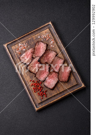 Grilled beef steak meat with salt and pepper. Beef steak grilled on a barbecue Grilled beef steak meat with salt and pepper. Beef steak grilled on a barbecue 129992902
