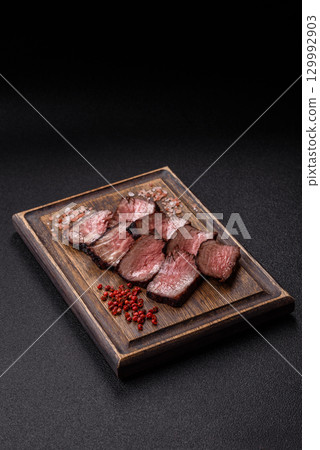 Grilled beef steak meat with salt and pepper. Beef steak grilled on a barbecue Grilled beef steak meat with salt and pepper. Beef steak grilled on a barbecue 129992903