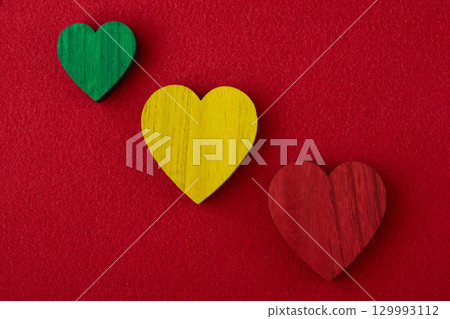 Traffic light colors wood hearts on the red fabric background. Traffic light colors wood hearts on the red fabric background. 129993112