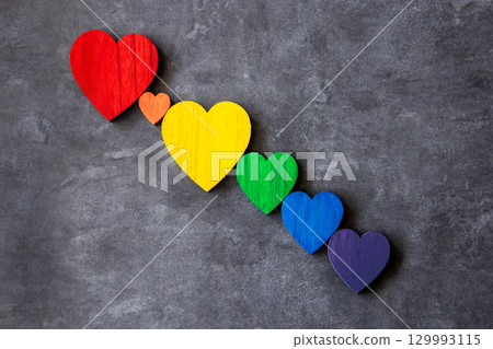 Rainbow colors wood hearts on the stone black background. Lgbt flag. Rainbow colors wood hearts on the stone black background. Lgbt flag. 129993115
