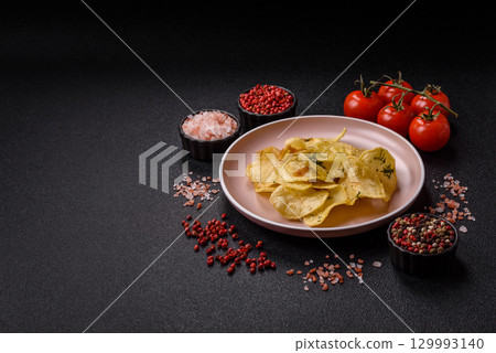 Crisps fried with salt, spices and garlic. Cooked potatoes 129993140
