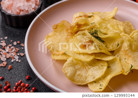 Crisps fried with salt, spices and garlic. Cooked potatoes Crisps fried with salt, spices and garlic. Cooked potatoes 129993144