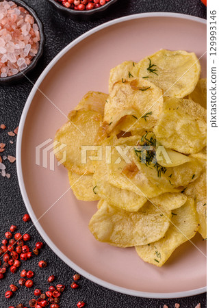Crisps fried with salt, spices and garlic. Cooked potatoes Crisps fried with salt, spices and garlic. Cooked potatoes 129993146