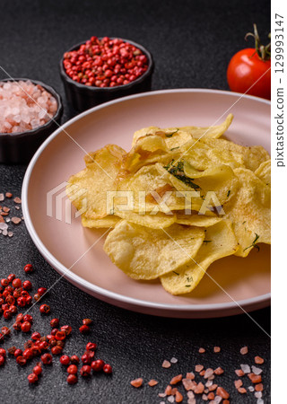 Crisps fried with salt, spices and garlic. Cooked potatoes 129993147