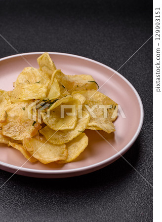 Crisps fried with salt, spices and garlic. Cooked potatoes Crisps fried with salt, spices and garlic. Cooked potatoes 129993151
